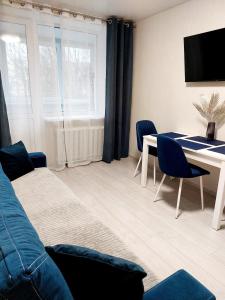 赫梅利尼茨基Свежая 2-комнатная квартира в центре的客厅配有蓝色的沙发和桌子