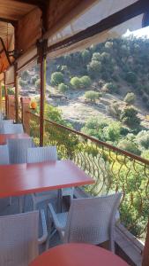 Kasba des Aït MoussaGite Rahhaoui Simo的设有带桌椅的阳台,享有山丘美景