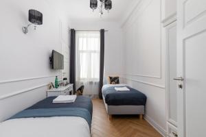 华沙Rent like home - Lwowska 9的一间卧室设有两张床、一张桌子和一个窗口。