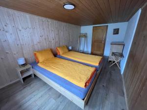 格施塔德Alpenchalet Haldeli Gstaad Ferienwohnung im 1-Stock的木制客房内的一间卧室配有两张床