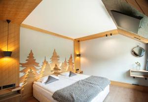 波罗维茨"Park Hotel Ela"的一间卧室设有床铺和一面带圣诞树的墙壁