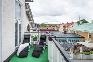 特鲁萨特鲁萨瑞典历史酒店的大楼内的阳台配有椅子和绿色地板