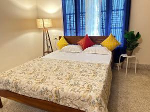 迈索尔Palace Hostel by Borrbo的一间卧室配有带色彩缤纷枕头的床