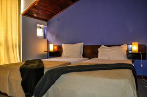 里贝拉布拉瓦Bela Sombra的卧室设有两张床铺,拥有蓝色的墙壁