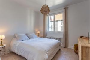 多维尔Le Carrousel - Appartement avec studio attenant的卧室配有白色的床和窗户。