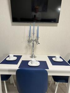 赫梅利尼茨基Свежая 2-комнатная квартира в центре的一张带两把蜡烛和蓝色椅子的蓝白桌子