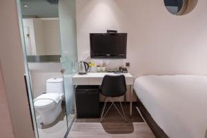 台北雀客旅馆台北信义的小房间设有一张床和一张书桌及电视