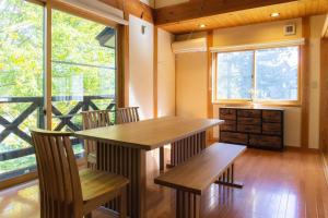信浓VILLA SHINANO的一间带桌子和2个长凳的用餐室