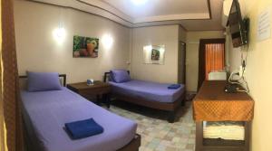 彭世洛วังอินธารา รีสอร์ท (Wangintara Resort)的酒店客房设有两张床、一张桌子和一张书桌。