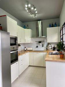 科斯塔特吉塞La Mar Poolvilla的厨房配有白色橱柜和蓝色花瓶