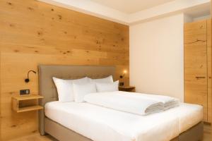 施勒肯Heimat 1495m Appartement TYP 4的卧室配有白色的床和木墙