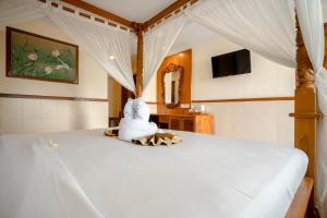 库塔峇里岛棕榈滩大酒店的坐在床上的白色填充动物