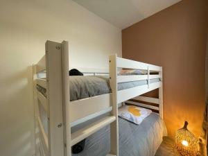 桑斯Le Cocon familial de la gare的一间卧室配有两张双层床和一盏灯。