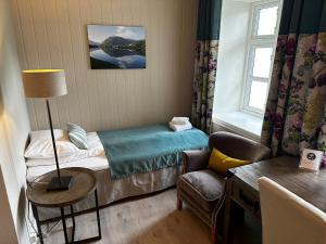 松达尔霍夫隆德峡湾酒店的小房间设有一张床和一把椅子