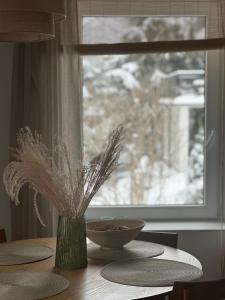 KrzyżowaW deSki dom apartamenty的桌子上带花瓶的桌子,带窗户