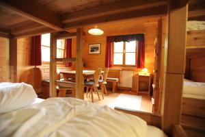 AubergGalsterbergalm Jagdhütte的卧室配有一张床和一张桌子及椅子