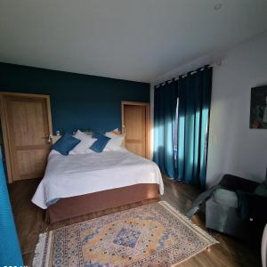 PontillasGite avec piscine La Buissiere - Fernelmont的一间卧室配有一张带蓝色墙壁的大床