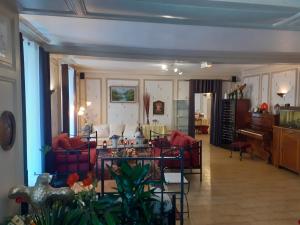 蒂耶尔Aigle d'Or的客厅配有红色沙发和钢琴