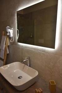 莱韦拉诺Masseria Tenuta Flora Maria的浴室设有白色水槽和镜子