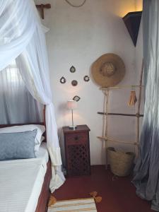 拉穆Pwani House - Lamu Seafront的一间卧室配有一张床和一张带台灯的桌子