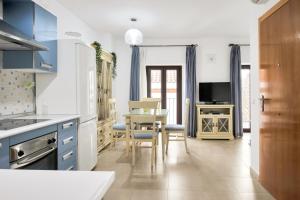 隆达GAV La Ermita的厨房配有蓝色橱柜和桌椅