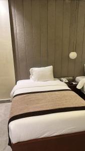 开罗فندق أورو بلازا ORO Plaza Hotel的一间卧室配有一张带白色床单的大床