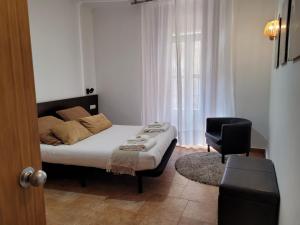 瓦伦西亚瓦伦西亚生活公寓 - 默塞德的卧室配有床、椅子和窗户。