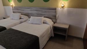 圣巴巴拉Hotel Venta de la Punta的酒店客房带两张床和长凳