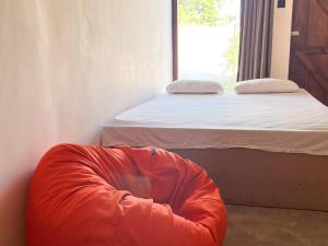 卡特勒格默Agastyā的一间卧室配有一张床和橙色豆袋椅