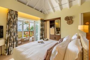 古斯塔维亚Tropical Hotel St Barth的卧室设有一张白色大床和一扇窗户。