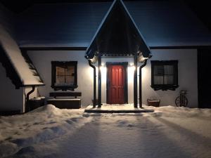 韦特利纳Szczęśliwy Domek的雪中带红门的房子