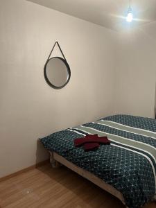 圣但尼une maison en ville的卧室配有一张壁挂镜子的床