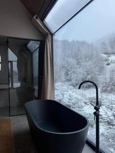 BogëNorth Alpine Villas的浴缸位于窗户前