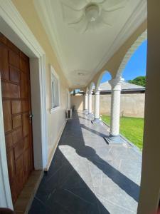 Senam Haus的一条有柱子和门的房子的空走廊