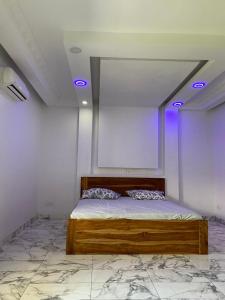 Senam Haus的天花板上蓝色灯的房间里一张床位