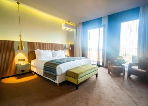 马拉喀什Hotel Le Rocher Marrakech的配有一张床和一把椅子的酒店客房