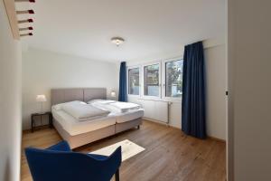 伦克山村公寓的一间卧室配有一张床和一张蓝色椅子