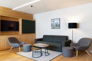 施勒肯Heimat 1495m Appartement TYP 5的客厅配有沙发、两把椅子和一张桌子