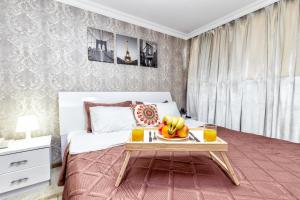阿斯塔纳Hotel Bed and Breakfast的一间卧室配有一张床铺,桌子上放有水果盘