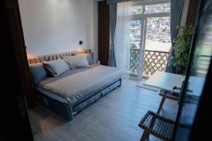 碧瑶Tinker's Cabin Baguio的一间卧室设有一张床和一个大窗户