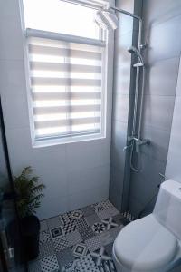 碧瑶Tinker's Cabin Baguio的带淋浴和卫生间的浴室以及窗户。