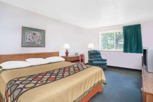 昆斯伯里格伦斯福尔斯速8酒店的酒店客房带一张大床和一把椅子