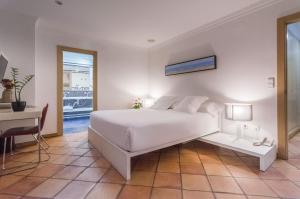 德尼亚Hotel Nou Romà的白色卧室配有床和书桌