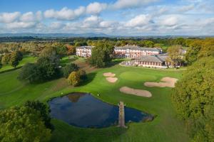 格洛斯特Hilton Puckrup Hall Hotel & Golf Club, Tewkesbury的享有带高尔夫球场的豪宅的空中景致
