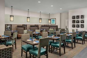 罗斯芒特芝加哥奥黑尔机场罗斯蒙特希尔顿逸林酒店的大型用餐室配有桌椅