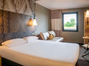 圣乔治得戈宜必思彭托森湾圣米歇尔山酒店 的酒店客房设有一张白色大床和椅子