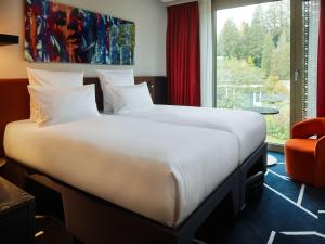巴登-巴登TRIBE Baden-Baden的一张位于酒店客房的大床,设有窗户