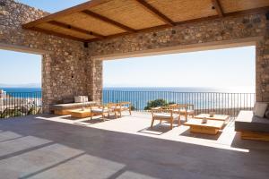 Ágios FokásKOIA All - Suite Well Being Resort - Adults Only的一个带桌椅的海景庭院