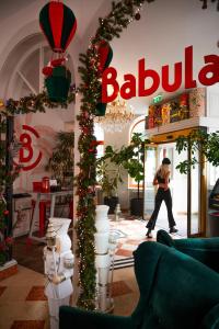 维也纳Hotel Babula am Augarten的一位穿着圣诞装饰品的女人走进商店