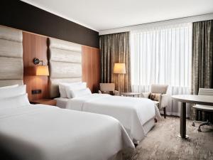 华沙华沙威斯汀酒店的酒店客房设有两张床和一张桌子。